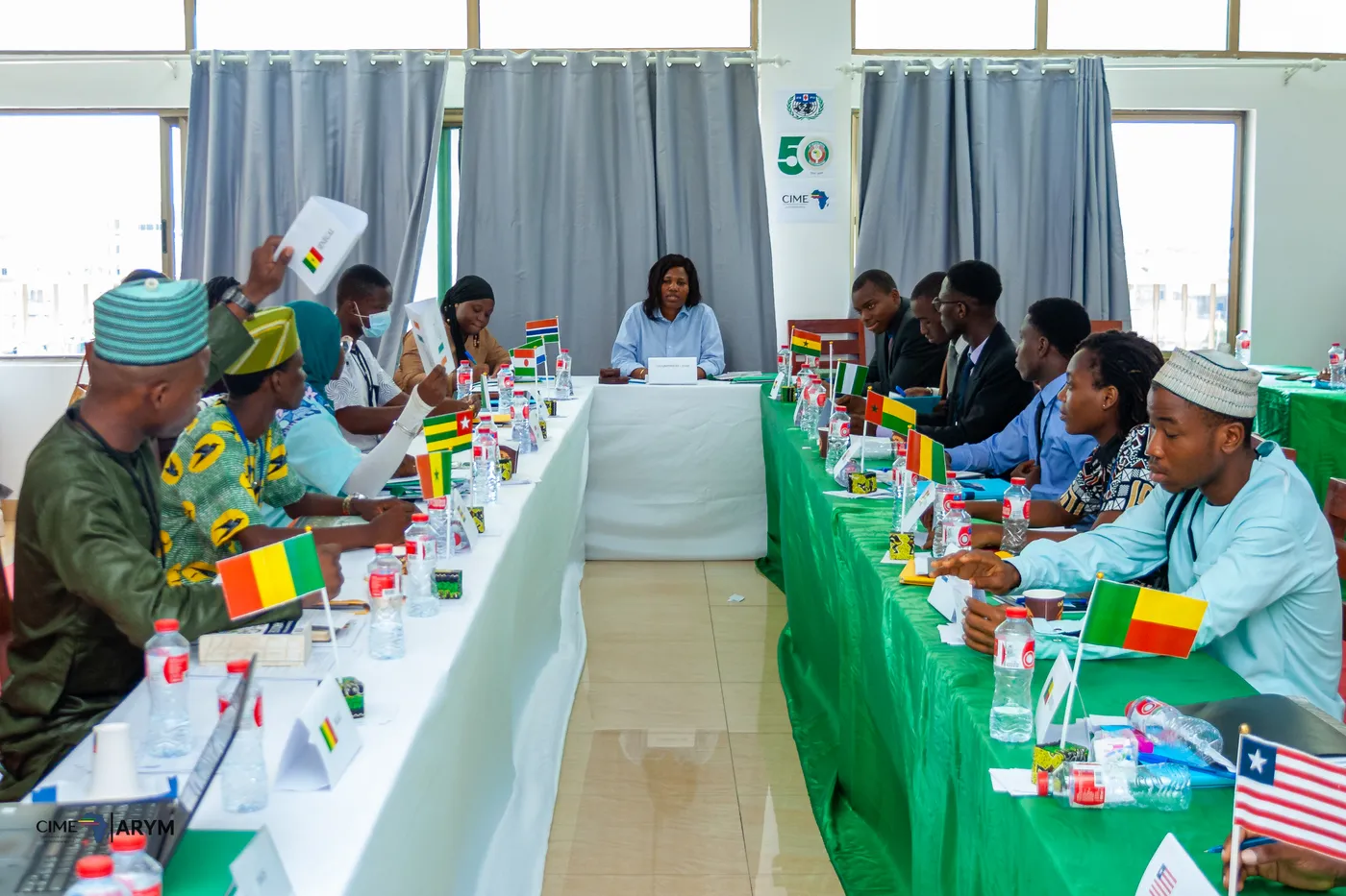 Séance de simulation WARIC : délégués derrière les drapeaux de leurs pays, présidente de séance au centre