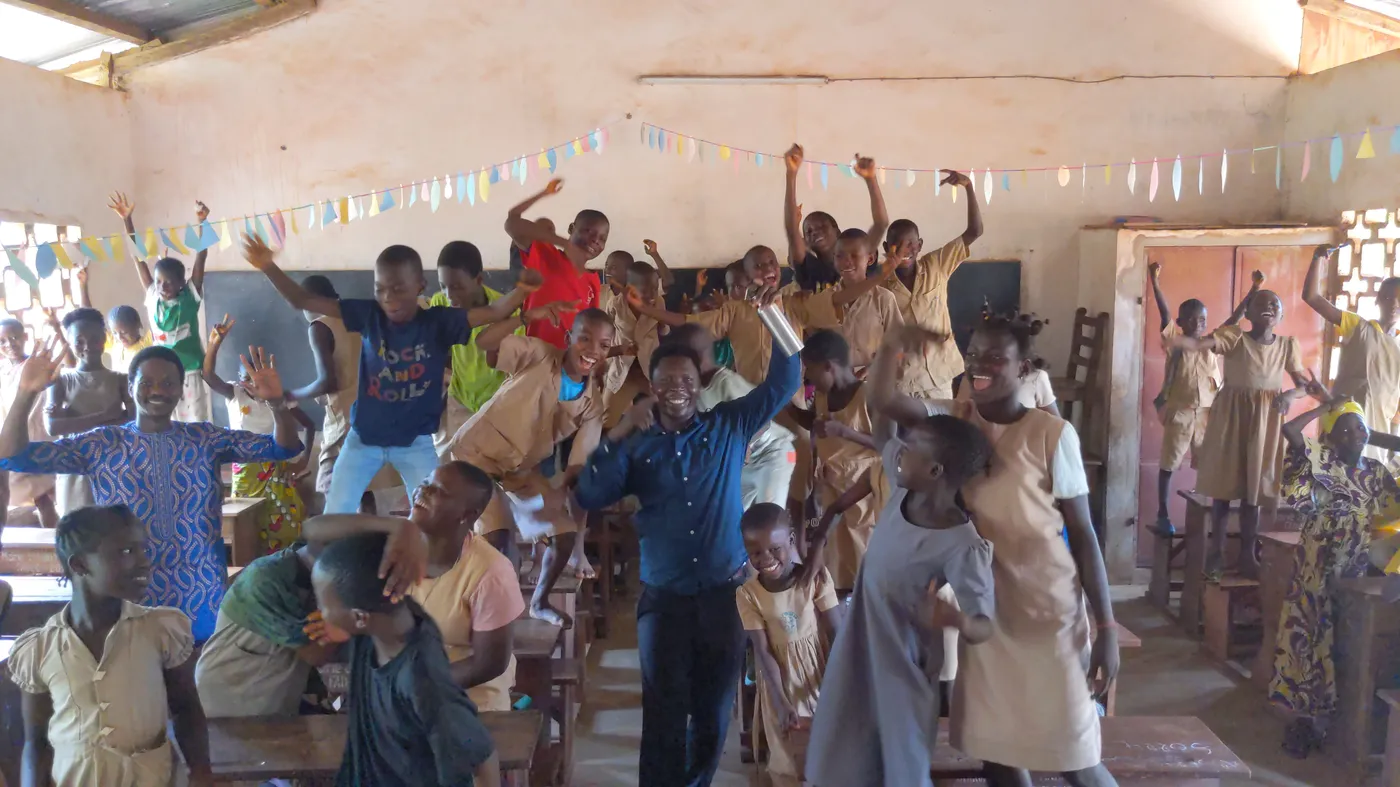 Classe d'enfants enthousiastes levant la main pendant un programme Morgan Training